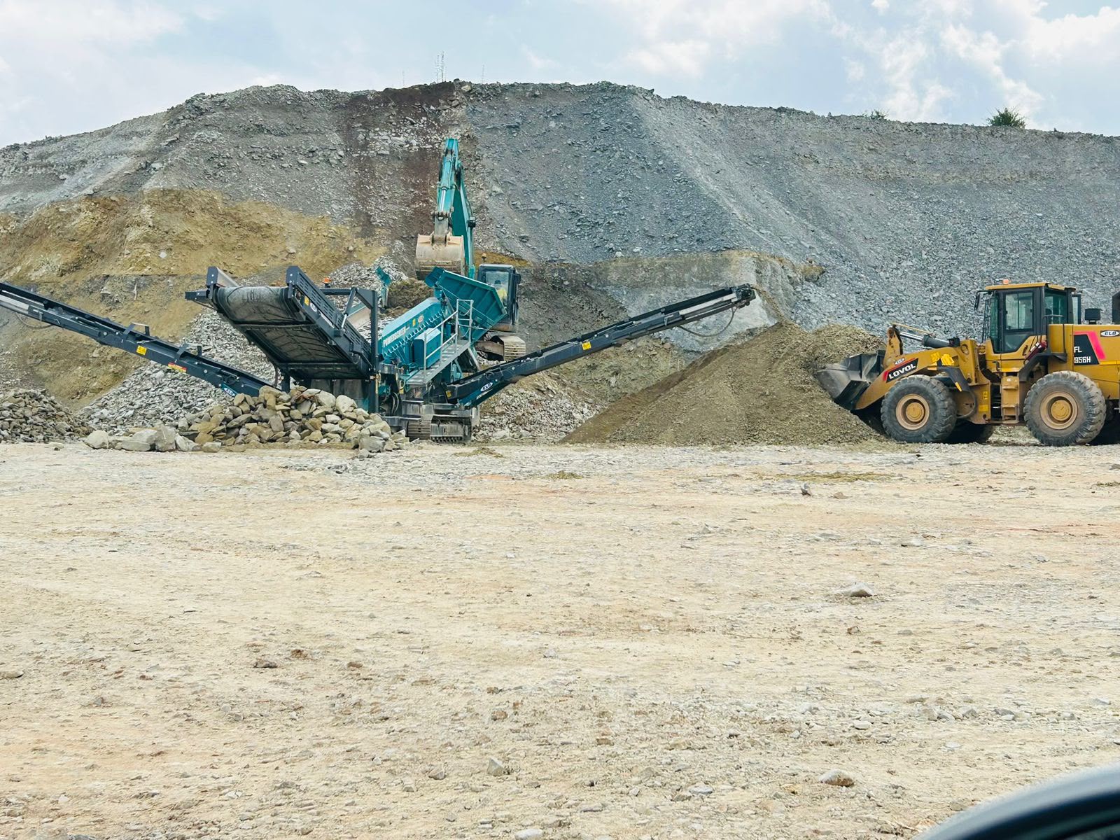Quarry screening plant with conveyor, wheel loader and excavator — civil works in progress